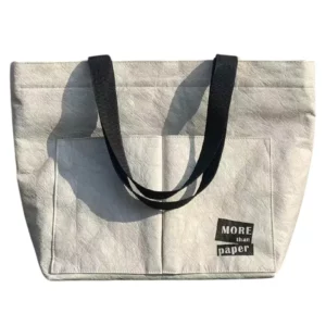 White Dupont paper bag with black handles and text on front pocket
